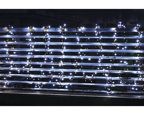 LED-Lichterkette mit kaltweißen und warmweißen Lichtern an einem Balkongeländer bei Nacht.