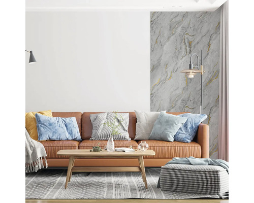 Modernes Wohnzimmer mit braunem Ledersofa, Holztisch und Vliestapete in Marmoroptik mit Goldakzenten an der Wand.