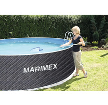 Eine Person reinigt einen runden Marimex Gartenpool in Rattanoptik mit einer Poolleiter und einem Kescher.