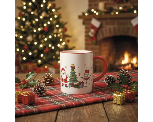 Weiße Keramiktasse mit Weihnachtsmotiven auf einem karierten Läufer vor einem beleuchteten Weihnachtsbaum und einem Kamin.