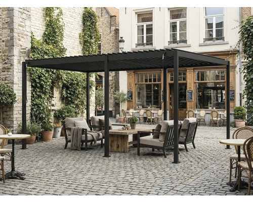 Freistehende Pergola mit Lamellendach aus Aluminium, Lounge-Möbel mit Holz-Tisch auf gepflastertem Innenhof.