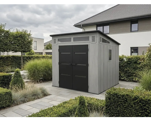 Modernes Gerätehaus mit grauen Wänden in Holzoptik, schwarzen Doppeltüren und Fenstern, stehend auf Steinplatten in einem Garten.