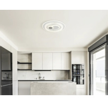 Moderne, helle Küche mit weißen Schränken, einer Kücheninsel in Steinoptik und einer runden LED-Deckenleuchte im minimalistischen Stil.