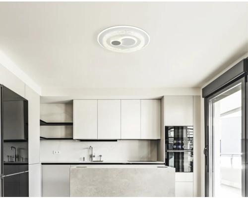 Moderne, helle Küche mit weißen Schränken, einer Kücheninsel in Steinoptik und einer runden LED-Deckenleuchte im minimalistischen Stil.