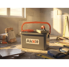 AkKit Fliesenwaschset mit Eimer, Rollenaufsatz und Schwammbrett auf einer Baustelle mit Fliesen, Kleber und Werkzeugen.