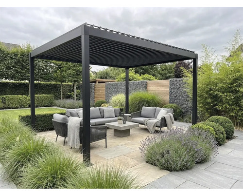 Moderne Lamellen-Pergola aus Aluminium über einer Sitzgruppe mit grauen Gartenmöbeln auf einer Steinterrasse inmitten einer Gartenanlage.