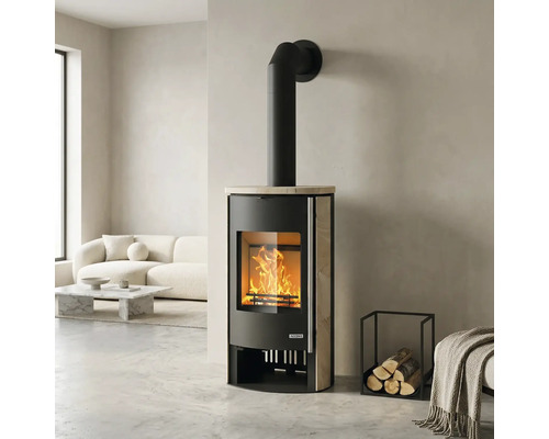 Kaminofen mit Natursteinverkleidung und brennendem Feuer in einem hellen, modernen Wohnzimmer mit weißem Sofa.