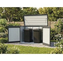 Geöffnete Mülltonnenbox aus Metall mit zwei schwarzen Mülltonnen auf gepflasterter Fläche im Garten.