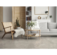 Modernes helles Wohnzimmer mit grauen Bodenfliesen in Natursteinoptik, Holzmöbeln und grauem Sofa.