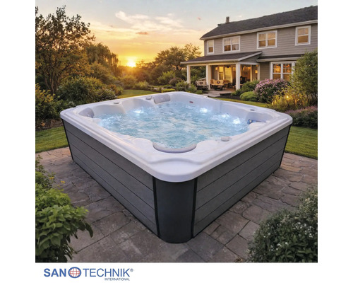 Quadratischer Außenwhirlpool mit grauer Verkleidung, sprudelndem Wasser und Beleuchtung auf einer Steinterrasse im Garten. Sanotechnik Logo.
