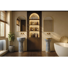 Elegantes Badezimmer mit zwei verzierten Säulenwaschbecken, Rundbogenspiegeln mit Goldrahmen, goldenen Wandarmaturen und einem Nischenregal aus Holz.