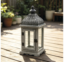 Gartenlaterne aus Holz und Metall mit Glaseinsätzen auf einer hellen Holzterrasse.