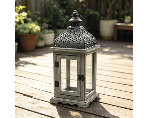 Gartenlaterne aus Holz und Metall mit Glaseinsätzen auf einer hellen Holzterrasse.