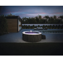 Intex aufblasbarer Whirlpool in Steinoptik auf einer modernen Terrasse mit Pool und Gartenmöbeln bei Abenddämmerung.