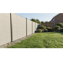 Moderner Sichtschutzzaun in Betonoptik mit Metallpfosten in einem gepflegten Garten mit Rasenfläche und Steinumrandung.