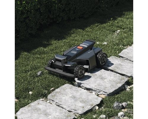 Segway Navimow Mähroboter überquert Gehwegplatten aus Stein in einer gepflegten Gartenanlage.