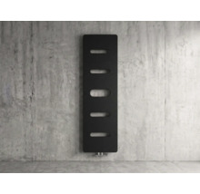 Vertikaler Design Heizkörper in Schwarz mit ovalen Aussparungen an einer Betonwand.
