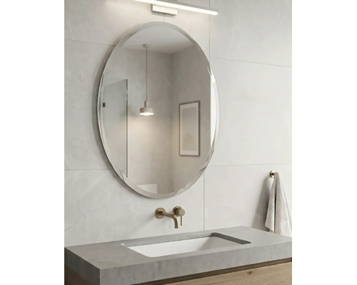 Moderner Badezimmerbereich mit einem ovalen Wandspiegel, einem Waschtisch aus Beton mit eingebautem Becken und einer Wandarmatur.