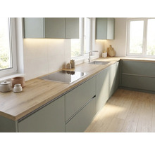 Moderne Einbauküche in L-Form mit grünen Fronten, einer Arbeitsplatte in Holzoptik, integriertem Kochfeld und Edelstahlspüle.