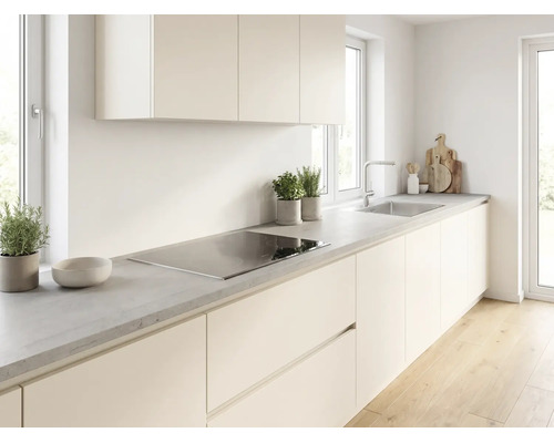 Helle moderne Küche mit cremefarbenen Fronten, grauer Arbeitsplatte in Betonoptik, Induktionskochfeld und Edelstahlspüle.