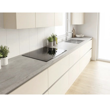 Moderne helle Küche mit Arbeitsplatte in Betonoptik, Induktionskochfeld, grifflosen Schränken und Edelstahlspüle.