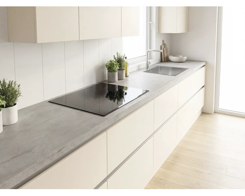 Moderne helle Küche mit Arbeitsplatte in Betonoptik, Induktionskochfeld, grifflosen Schränken und Edelstahlspüle.