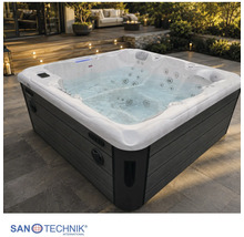 Sanotechnik Außenwhirlpool mit weißer Wanne und dunkler Verkleidung auf einer geräumigen Terrasse bei Dämmerung. Sanotechnik Logo.