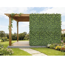 Holz-Pergola mit einer künstlichen Hecke als Sichtschutz in einem hellen, organisierten Garten mit Blumen und einem Steinweg.