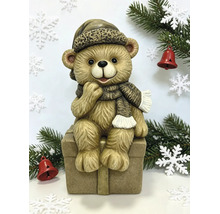 Weihnachtsfigur Teddybär sitzend auf einer Geschenkbox mit Mütze und Schal.