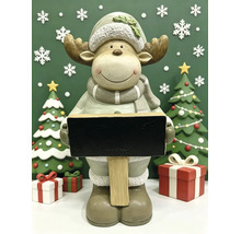 Weihnachtsdekoration mit einer Elchfigur, die eine Kreidetafel hält, umgeben von zwei Tannenbäumen, Geschenken und Schneeflocken.
