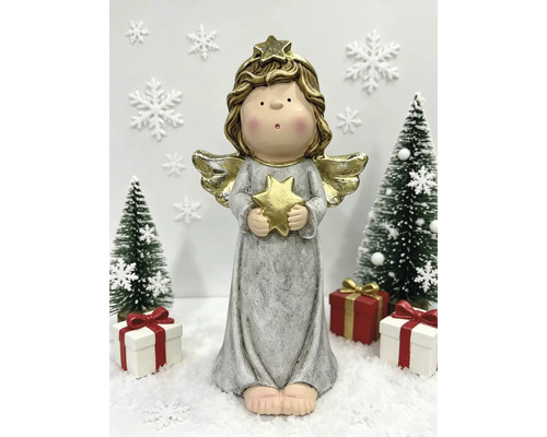 Weihnachtsengel-Figur mit goldenem Stern in den Händen, umgeben von kleinen Tannenbäumen und Geschenken auf Schnee.