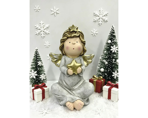 Sitzende Engelsfigur mit goldenem Stern flankiert von Tannenbäumen und Geschenken in einer winterlichen Schneelandschaft.