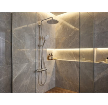 Moderne Dusche mit verchromtem Regenduschsystem, Fliesen in Marmoroptik, Holzboden und beleuchteter Wandnische.