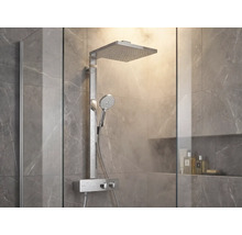 Modernes Duschsystem mit quadratischer Regendusche, Handbrause und Thermostatarmatur in einer hellen Dusche mit Marmorfliesen.