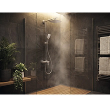 Modernes Badezimmer mit ebenerdiger Dusche, Regenduschkopf, Holzrost, Fliesen in Steinoptik, Handtuchheizkörper und Pflanzen.