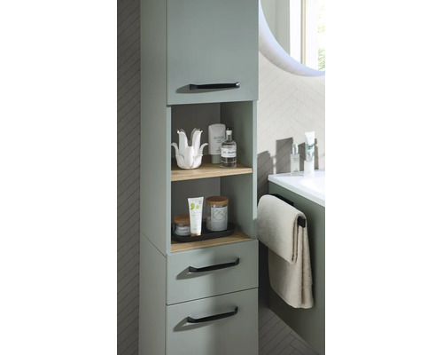 Moderner Bad-Midischrank in Salbeigrün mit offenen Holzregalen, Schubladen und schwarzen Griffen in einem hellen Badezimmer.
