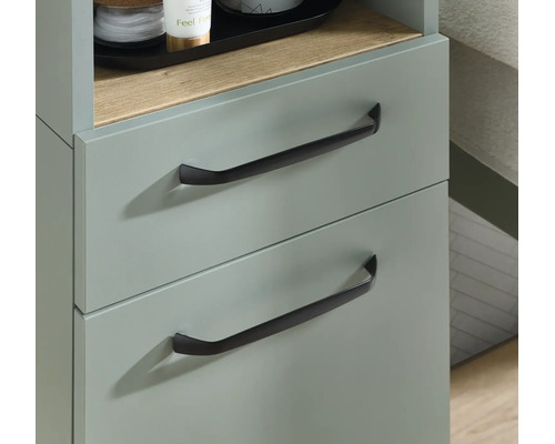 Grüner Badschrank mit zwei Schubladen, schwarzen Griffen und einer offenen Ablage in Holzoptik.