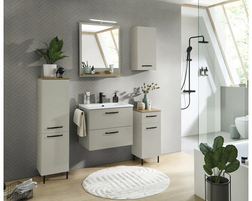 Hellgraues Badezimmer-Set bestehend aus Waschtischunterschrank, Spiegel, Hochschrank und Beistellschrank vor grauer Wand in Fischgrätoptik.