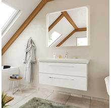 Moderner weißer Waschtisch mit Waschbecken und beleuchtetem Spiegel in einem hellen Badezimmer mit Dachschräge und Holzbalken.