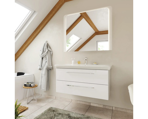 Moderner weißer Waschtisch mit Waschbecken und beleuchtetem Spiegel in einem hellen Badezimmer mit Dachschräge und Holzbalken.