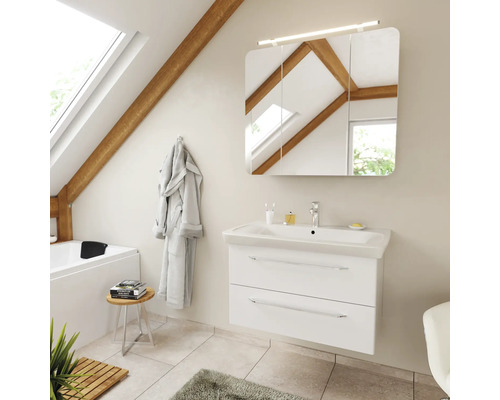 Badezimmer mit weißem Waschtischunterschrank, Keramikwaschbecken und dreitürigem Spiegelschrank mit Beleuchtung in einem hellen Dachgeschossraum.