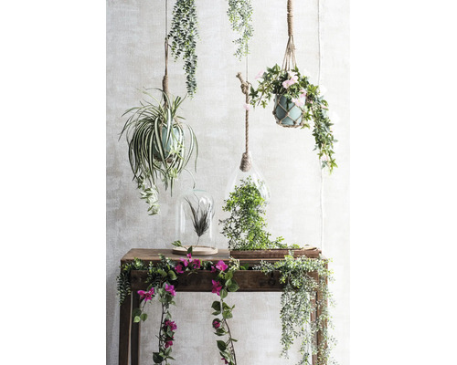 Dekorative künstliche Hängepflanzen, Terrarien und Blumenranken auf einem hölzernen Konsolentisch.