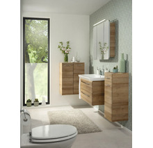 Modernes Badezimmer-Set in Eichenoptik mit Waschtisch, Spiegelschrank und Hängeschränken vor einer gemusterten Wand.