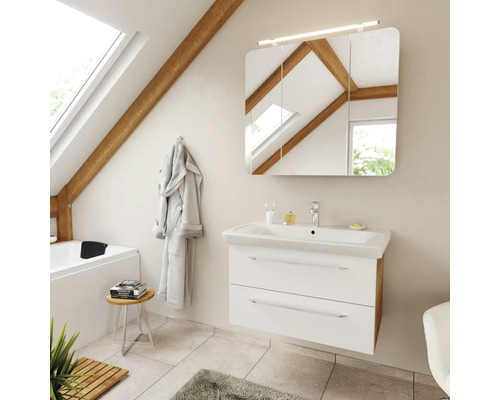 Modernes Badezimmermöbel-Set mit weißem Unterschrank, Waschtisch und Spiegelschrank in einem hellen Badezimmer mit Dachschräge und Holzbalken.