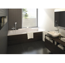 Modernes Badezimmer mit weißer Rechteck-Badewanne, dunkler Verkleidung in Holzoptik, Aufsatzwaschbecken auf dunklem Unterschrank und großem Fenster.