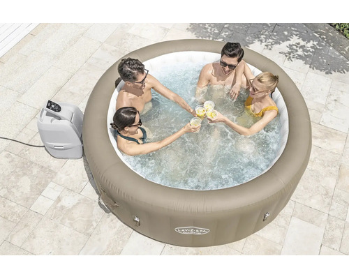 Vier Personen in einem runden aufblasbaren Whirlpool Lay-Z-Spa Palm Springs auf einer Terrasse mit sprudelndem Wasser und externer Pumpe.