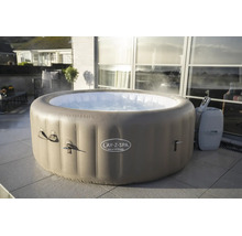 Runder, aufblasbarer Whirlpool Lay-Z-Spa Palm Springs auf einer Fliesenterrasse vor einer Glasfront mit dampfendem Wasser.
