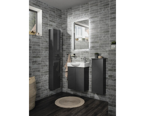 Modernes Badezimmer-Set mit dunkelgrauem Unterschrank, weißem Waschbecken, passenden Hängeschränken und beleuchtetem Spiegel vor grauer Fliesenwand.