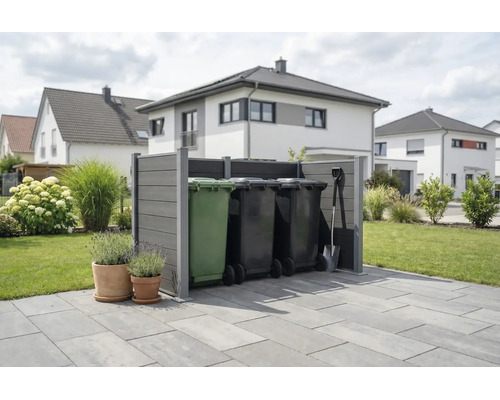 Moderne graue Mülltonnenverkleidung aus Verbundwerkstoff auf einer Terrasse in einem organisierten Garten mit Wohnhäusern im Hintergrund.