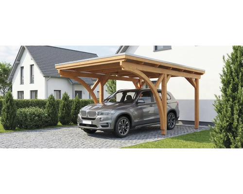 Einzelcarport aus Holz mit Flachdach und gebogenen Stützen, mit einem Auto auf einer gepflasterten Einfahrt vor einem Haus.